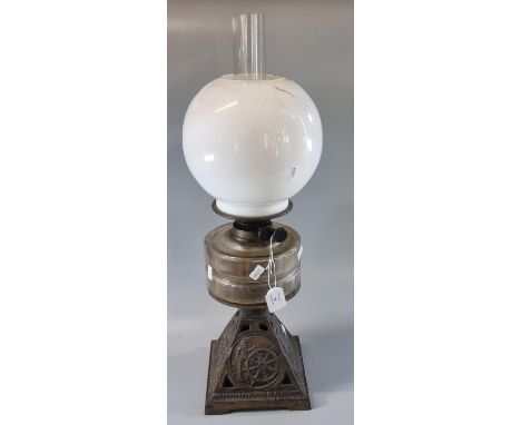 Early 20th Century double oil burner lamp having opaline glass globular shade above a glass reservoir, on a cast metal base d