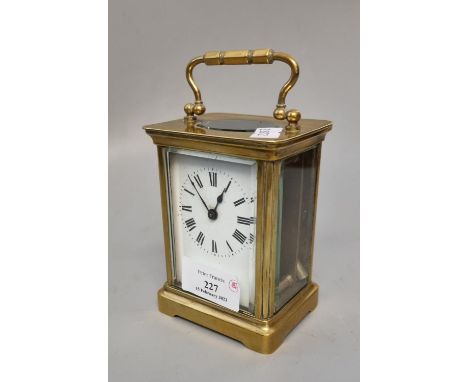 Early 20th century brass carriage clock with enamel face and Roman numerals, with key.  (B.P. 21% + VAT) 