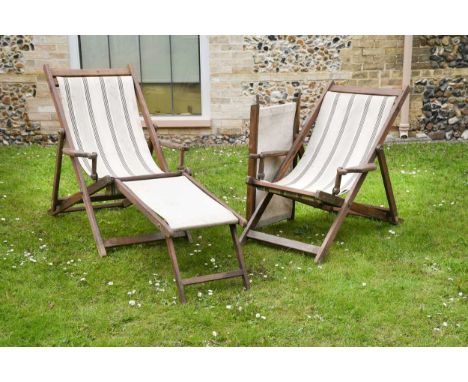 A pair of good Edwardian teak-framed deck chairs with detachable foot rests,  both with their original vintage striped canvas
