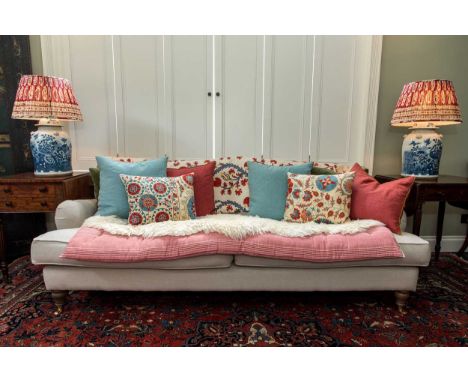 A three seater sofa, modern, on turned front legs and castors, upholstered in a stone coloured linen82 x 215 x 85cmtogether w