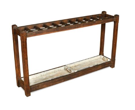 A Gothic revival oak 'club' stick stand, late 19th century, with 22 compartments and raised on stop-chamfered supports with w