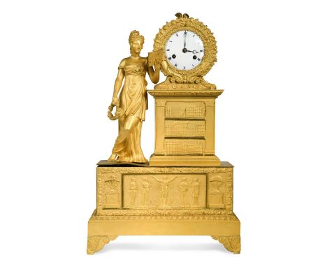 A French Empire style ormolu mounted mantel clock circa 1840, the enamel dial within a garlanded frame supported by a bookcas