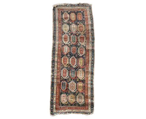 A Karabagh runner, late 19th century, with eight rows of three large boteh on a deep indigo ground310 x 108cm low pile and nu