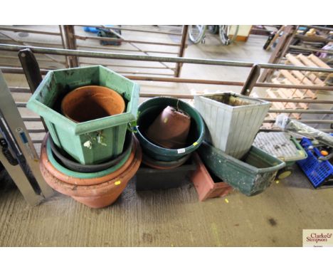 A quantity of plastic plant pots, tubs and a garden wheel caddy 