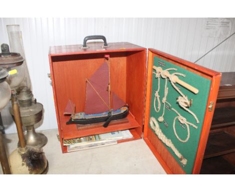 A model barge containing wooden case, door decorated with knotting diorama, local booklets