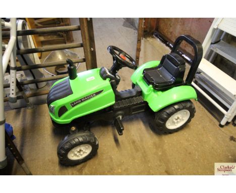 A plastic child's pedal garden tractor