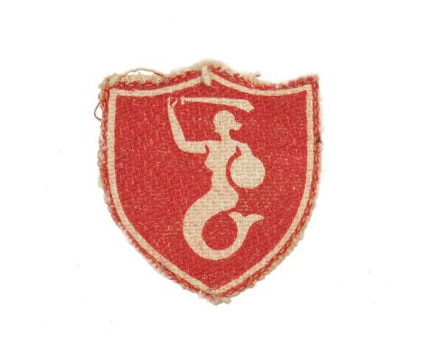Patch in form of a shield, made with red material, surrounded with white thread. Inside the shield visible a white mermaid wi