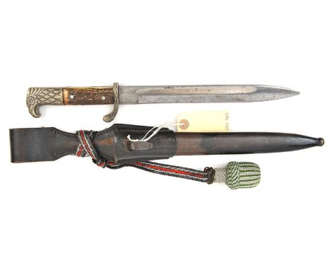 A Third Reich police sidearm, blade 9½”, eagle’s head pommel, staghorn grips, in its scabbard complete with frog and knot. GC