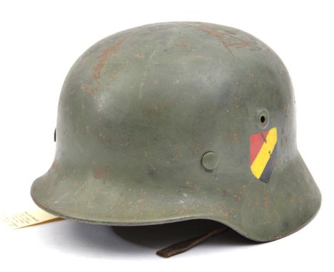 A Third Reich M1935 steel helmet,  decals repainted red/yellow/black, skull refinished at an early date, original markings in