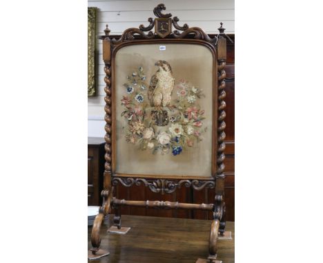 A Victorian carved walnut firescreen with needlework panel of a falcon W.68cm H.133cm