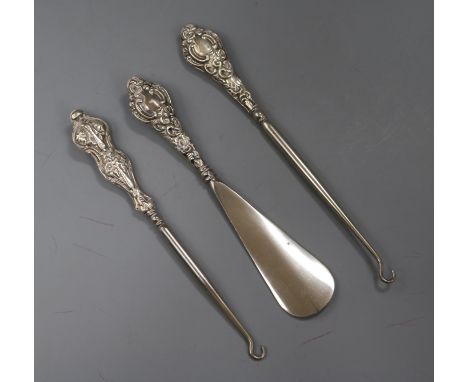 Two early 20th century silver handled button hooks and a silver handled shoe horn.