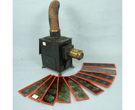 A tin magic lantern on four paw feet, with chimney, 39cm overall and ten glass slides by Ernst Planck.