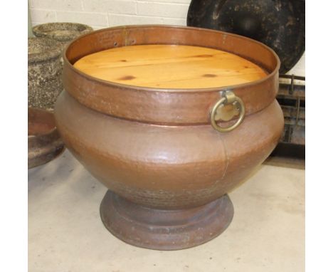 A large circular beaten copper two-handled planter, 72cm high, 83cm diameter.