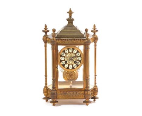 VICTORIAN BRASS CLOCK OF ARCHITECTURAL FORM WITH A CIRCULAR DIAL & FRENCH MOVEMENT, SIX GLASS PANELS & THREE BRASS PINAPPLE F
