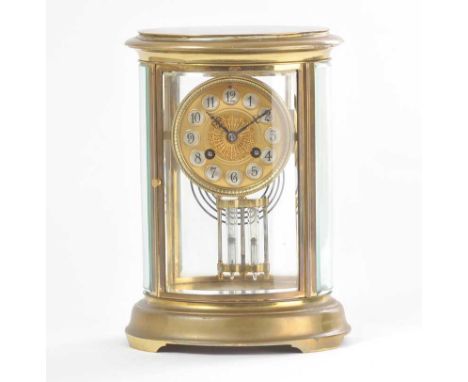 VICTORIAN OVAL BRASS MANTLE CLOCK WITH A CIRCULAR  BRASS DIAL & FOUR GLASS PANELS,HEIGHT: 10 INCHES, WIDTH: 7 INCHES, DEPTH: 