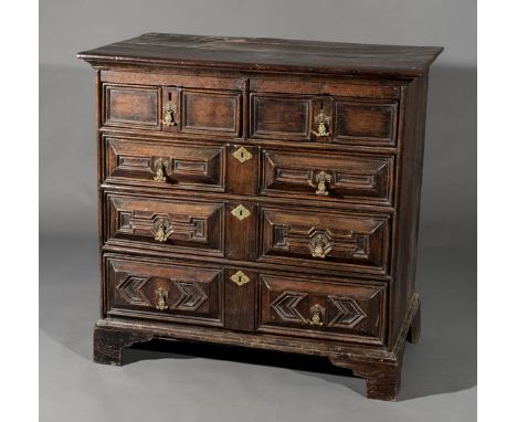 *Chest. An 18th century oak chest of drawers,  with two short and three long drawers each with brass cherub handles and engra