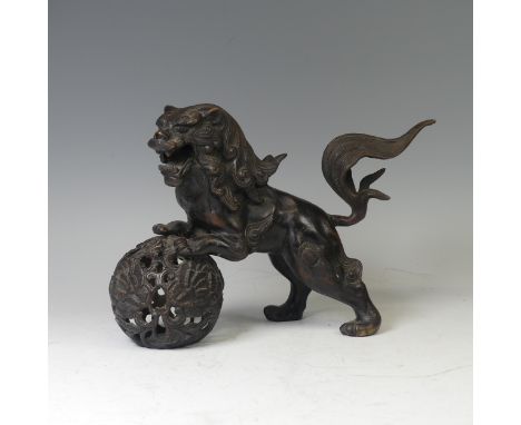 A 20th century Chinese bronze figure of a Foo Dog, modelled perched on ball, H 25cm.