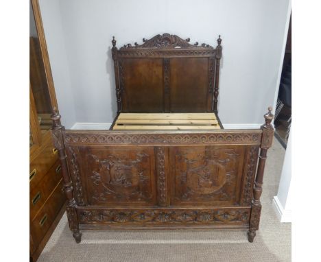 An early 19th century and later carved oak double Bedstead, the headboard detailed with foliate scrolls, the footboard with f