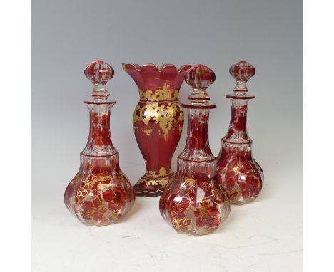 A near set of three 19th century Ruby Flash cut glass Decanters, marks to bases, H 25.5 cm, together with a later cranberry g