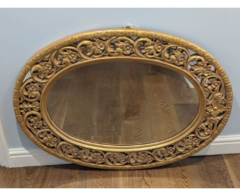 A Brights of Nettlebed oval gilt framed wall Mirror, with ornate scrolled and pierced decoration, W 106 cm x H 81 cm.
