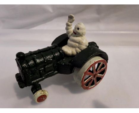 Cast iron Michelin Man on a tractor, H: 80 mm. UK P&amp;P Group 1 (£16+VAT for the first lot and £2+VAT for subsequent lots)