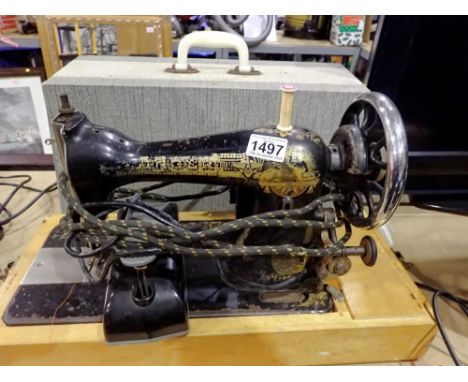 Cased Singer electric sewing machine, F199827, with pedal and power lead. All electrical items in this lot have been PAT test