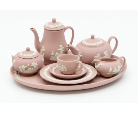 A Wedgwood pink jasperware miniature tea set consisting of tea, coffee pot, sugar bowl, milk jug, cup and saucer with tea pla