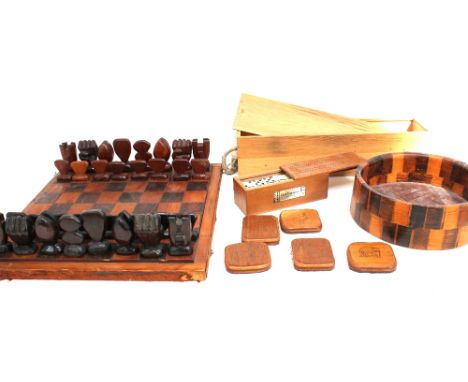 A carved wooden chess set with chessboard along with a wooden bowl and Matts boxed dominos.