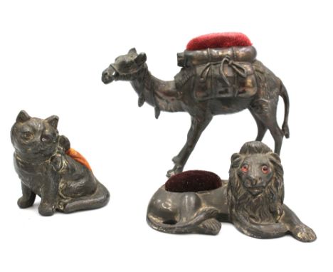 Three novelty 20th century base metal pin cushions comprising: a reclining Lion, with glass eyes, approx. 3,8cm high x 8cm lo
