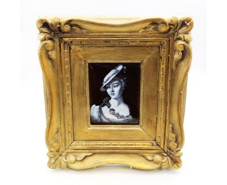 A 19th century Limoges en grisaille painted enamelled plaque, depicting a lady wearing flowers around her neck and hat on hea