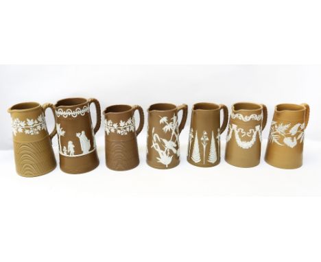 A selection of seven Dudson brown jugs, all with various white relief designs, all not stamped Dudson but with other marks, a