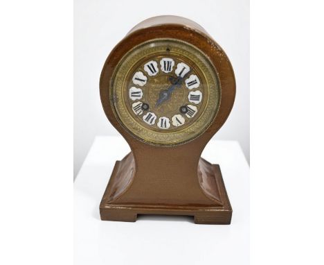 An unusual stoneware 8 day mantel clock, having brass dial with Arabic numerals, appears to be in working order, height 22cm