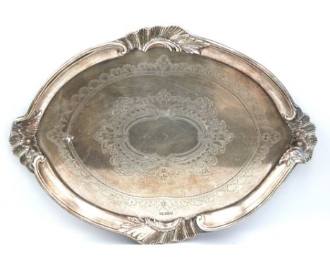 A late Victorian silver shaped oval tray, with elaborate scrolled sides incorporating four shells, with engraved decoration, 