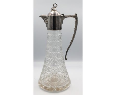 An Elizabeth II silver topped cut glass claret jug, spout decorated as a mans face with curved finial and foliate wrapped han