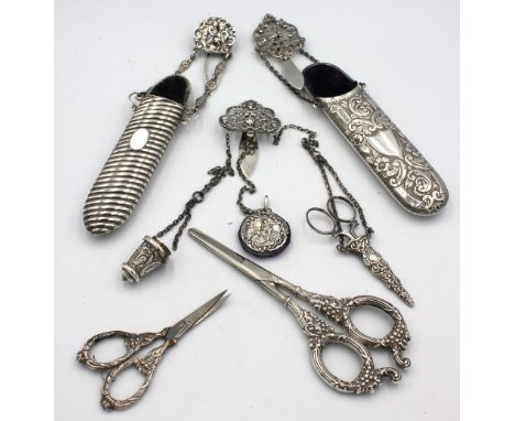 A late Victorian silver part chatelaine, having clip with foliate pierced design with three chains leading to a circular shap