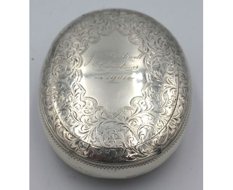 A late Victorian silver snuff box, of oval shape with engraved foliate decoration and engraved cartouche "JJ. Huckwell, Chris