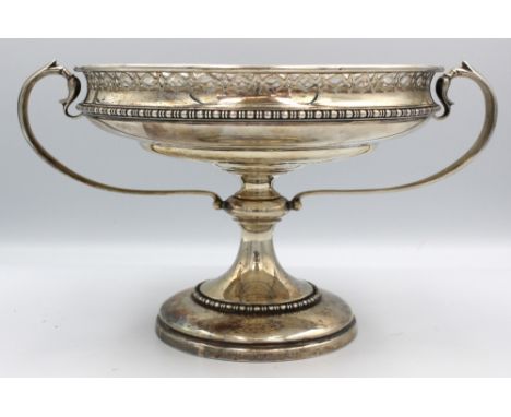 A George V silver comport or tazza, of circular shape with pierced rim and twin scrolled handles, upon a circular base with b
