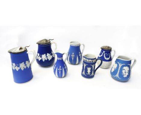 A collection of seven Dudson blue ground jugs, all with white relief designs, three with pewter covers, varying sizes. (7) Pr