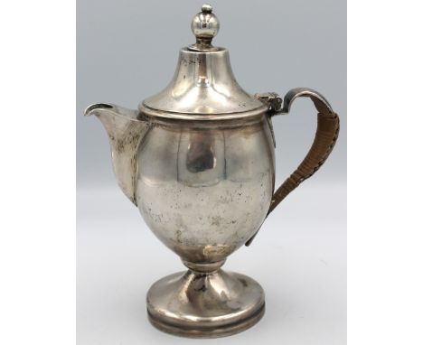 A George V Arts & Crafts style silver coffee pot, of urn shape upon circular foot, with planished handle with cane overlay an