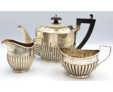 A matched Edwardian silver bachelors tea set, all of oval shape with gadrooned lower bodies, tea pot with ebonised wooden han