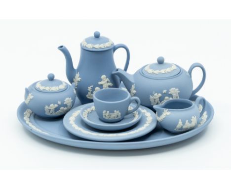 A Wedgwood blue jasperware miniature tea set consisting of tea, coffee pot, sugar bowl, milk jug, cup and saucer and tea plat