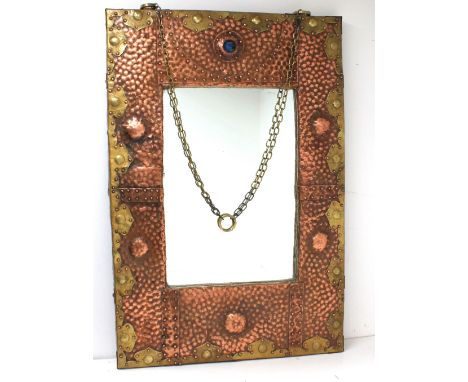 A mid 20th century Arts & Crafts style hammered copper and brass mounted wall mirror withy later parts, of rectangular shape 