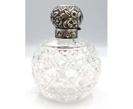 A Victorian silver topped cut glass scent bottle, body of globular form with silver collar and hinged cap, both with elaborat