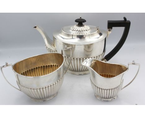 An Edwardian silver three piece tea set, all of oval shape with gadrooned lower bodies, tea pot engraved "Presented to Henry 