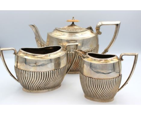 An Edwardian silver three piece tea set, each of oval form with gadrooned lower bodies, tea pot with angular handle with ivor