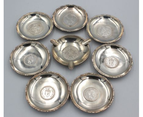 A collection of seven 20th century silver trinket dishes / pin trays, inset with coins comprising: a 1922 One Dollar inset wi