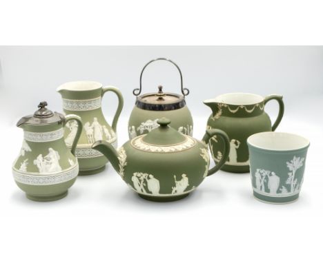 A small collection of Wedgwood green jasperware pieces comprising a tea pot, two milk jugs, covered jug, preserve jar with pl