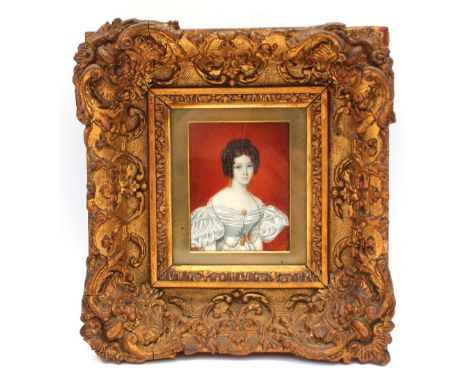 A mid 19th Century framed miniature portrait of a lady within a large gilt frame.
