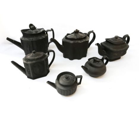 A collection of six Wedgwood or similar black basalt tea pots, varying moulded designs and sizes, one with swan finial. (6) C
