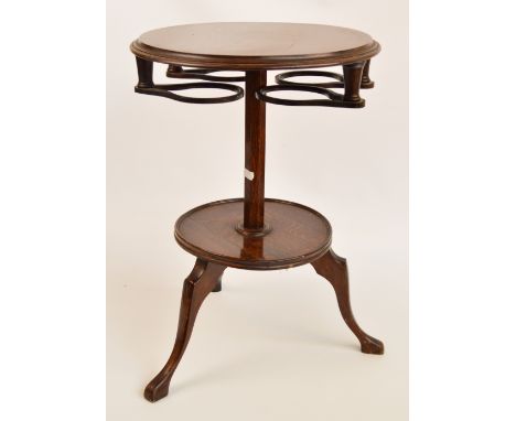 A vintage oak two tier circular occasional table with four unusual swivel action holders to underside of top surface, on trip